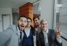 business team celebrating in office selfie