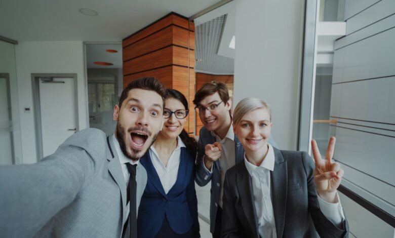 business team celebrating in office selfie
