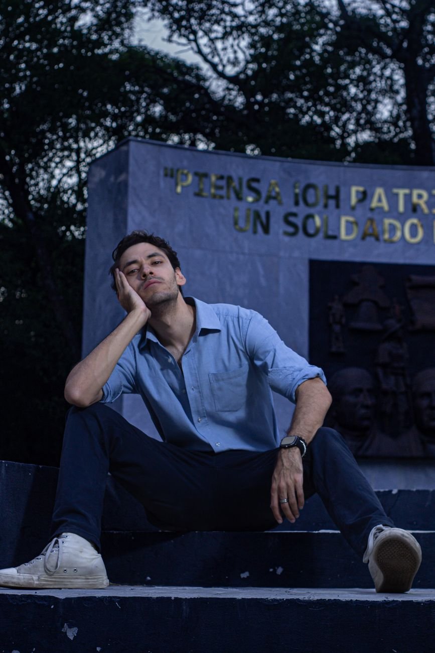 fashionable man sitting on steps in a park