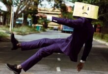 model in purple suit with unhappy face cardboard box