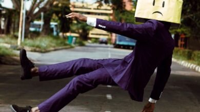 model in purple suit with unhappy face cardboard box