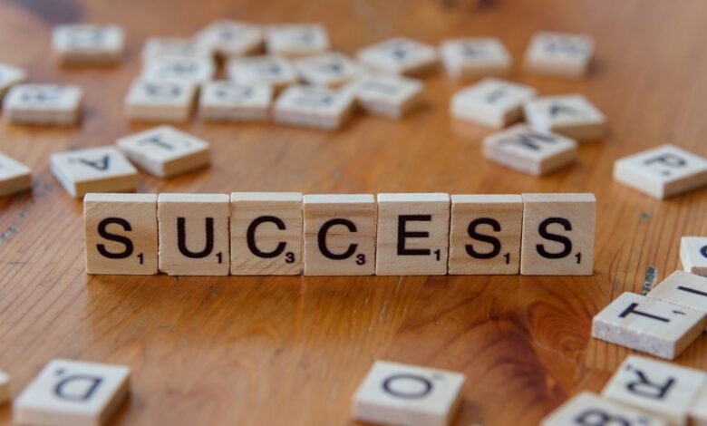 success concept with letter tiles on wooden surface