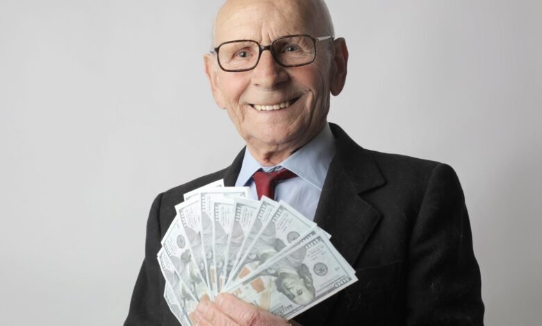 man in black suit holding dollar bills