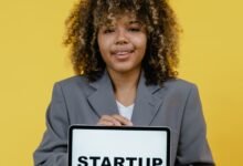 woman holding table computer standing near the yellow background