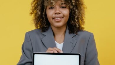 woman holding table computer standing near the yellow background