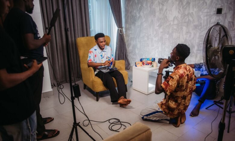 crew filming man sitting in armchair and talking