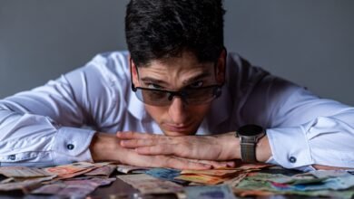 man contemplating argentine peso currency notes