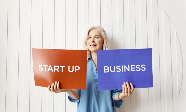 elderly woman holding orange and blue placard