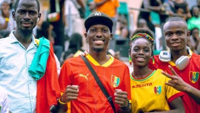 four happy soccer fans in colorful jerseys celebrating
