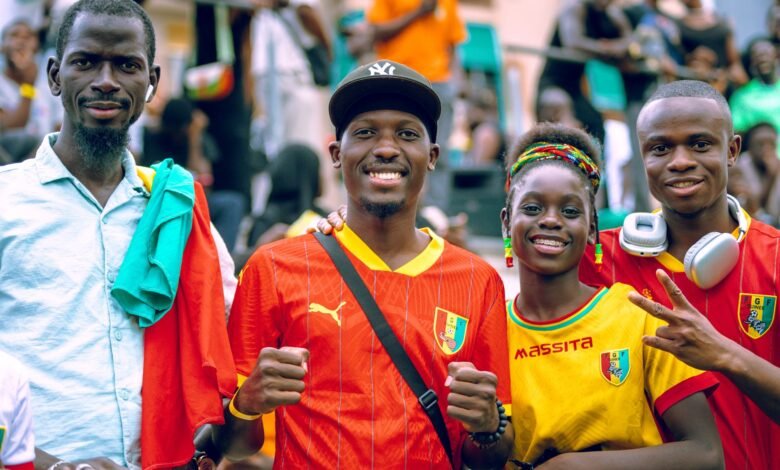 four happy soccer fans in colorful jerseys celebrating
