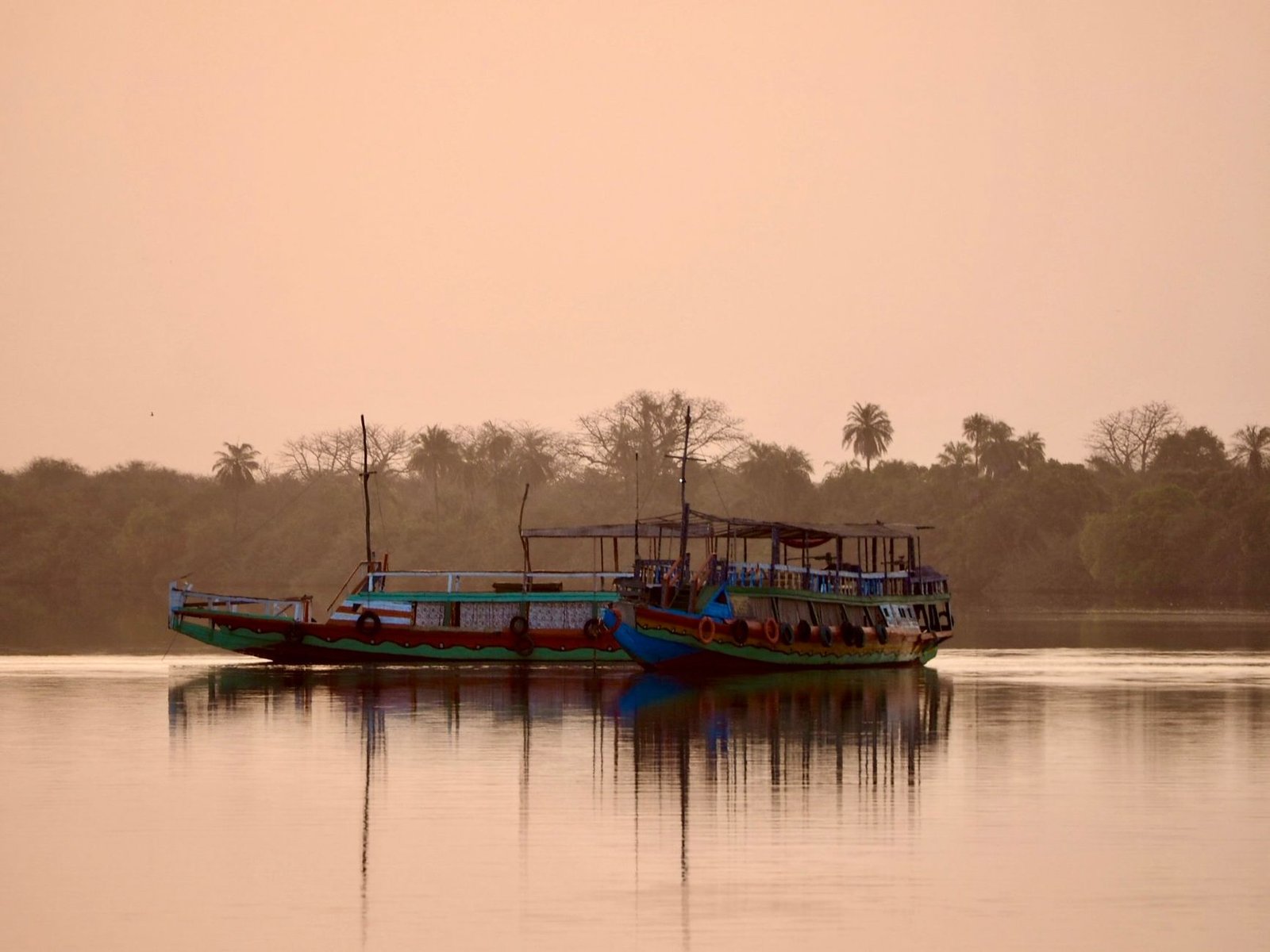 fishing boats in a lake during sunset
