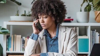 curly haired woman talking on phone in office