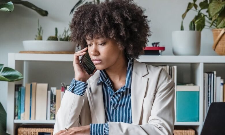 curly haired woman talking on phone in office