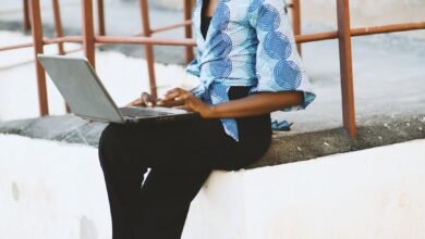 woman sitting on white concrete edge with railing