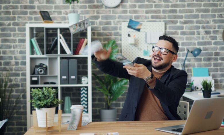 a man sitting at a desk in an office and throwing money