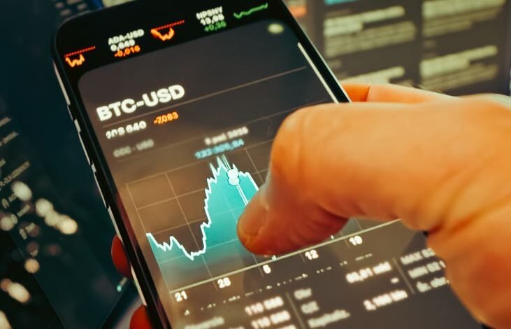 hand holding smartphone with cryptocurrency chart