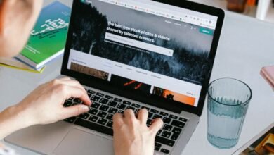 person using macbook on white table
