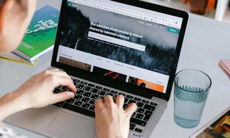 person using macbook on white table