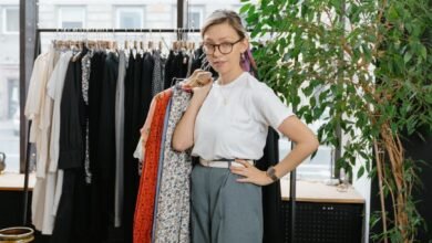 woman in white shirt holding clothes on hanger