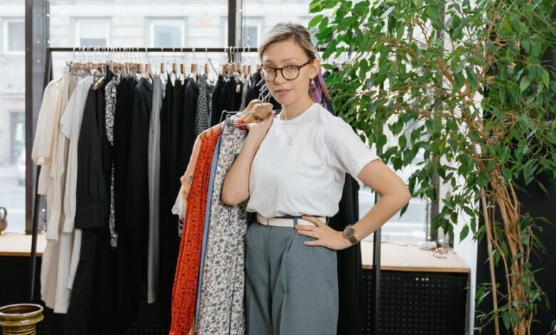 woman in white shirt holding clothes on hanger