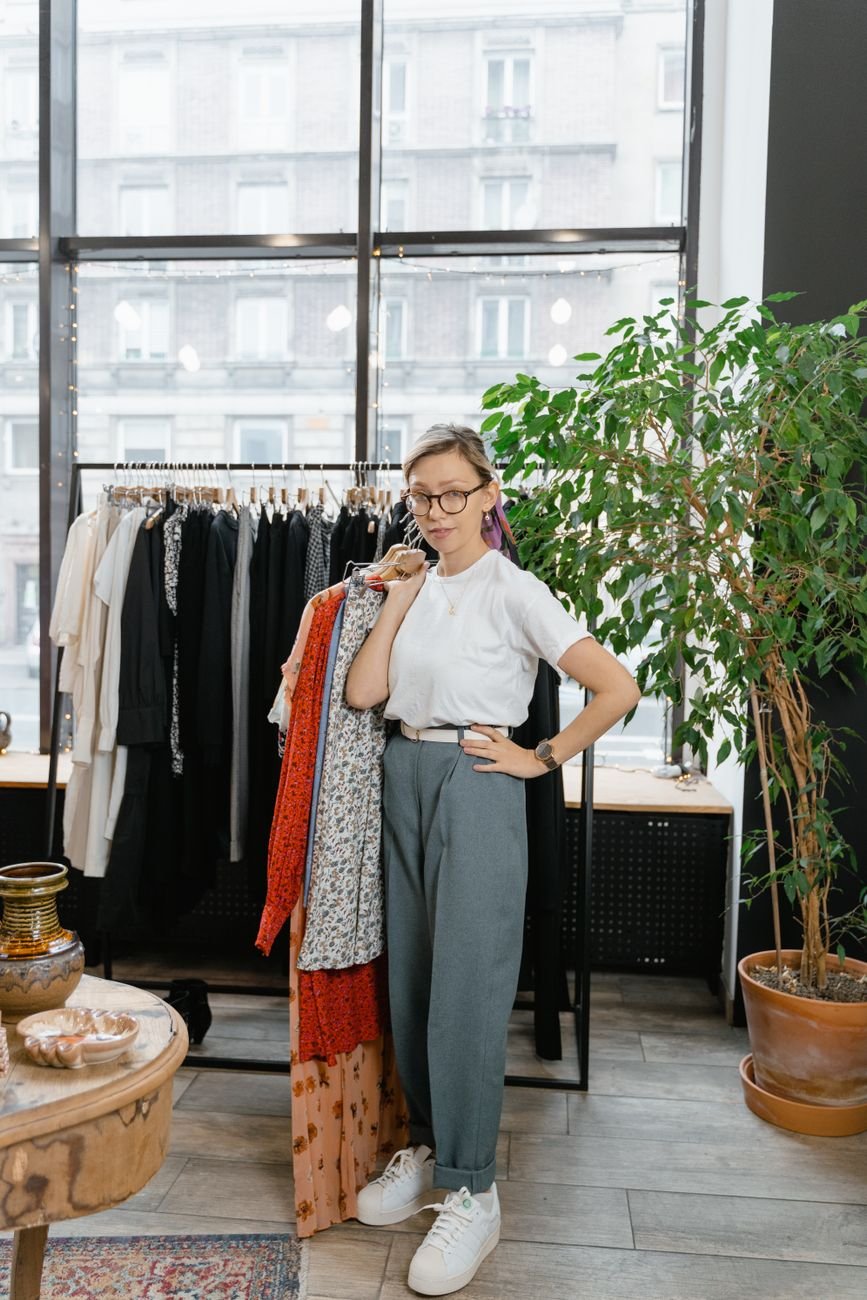 woman in white shirt holding clothes on hanger