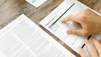 person holding white printer paper on wooden surface