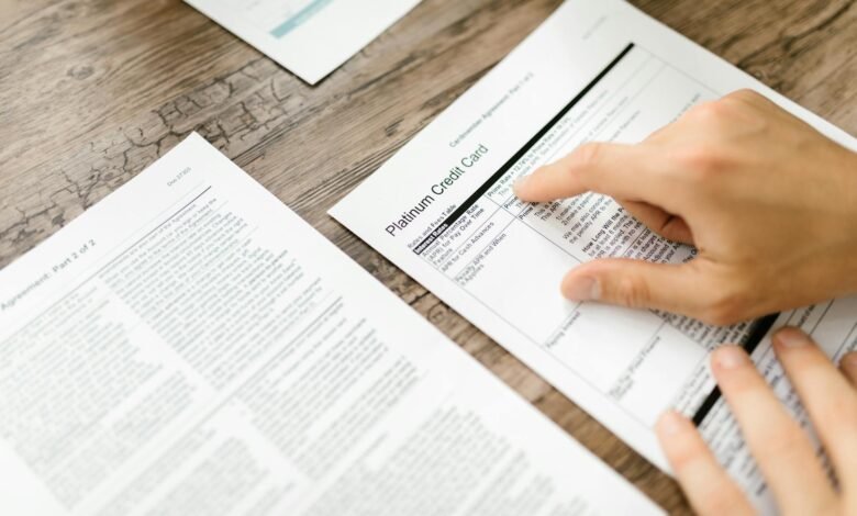 person holding white printer paper on wooden surface