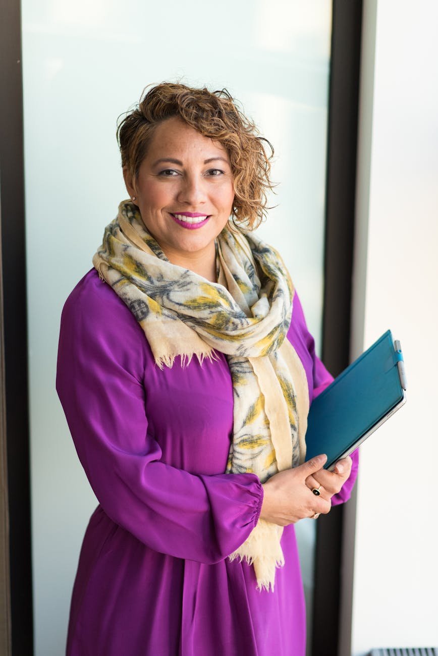 woman smiling and holding teal book