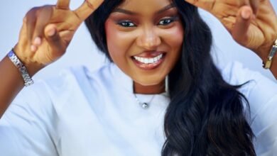 smiling woman making peace sign in white coat