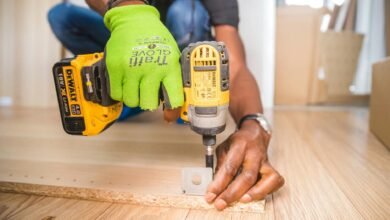 person using dewalt cordless impact driver on brown board