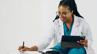 doctor using a tablet and taking notes in a notebook