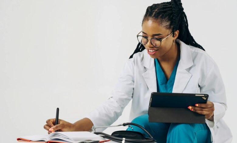 doctor using a tablet and taking notes in a notebook