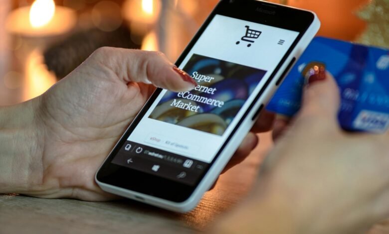 person using black and white smartphone and holding blue card