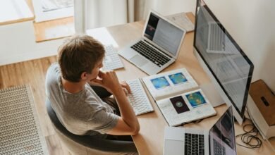 high angle shot of a boy sitting on grey chair while using his laptop computers