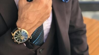 man in formal suit jacket holding his necktie