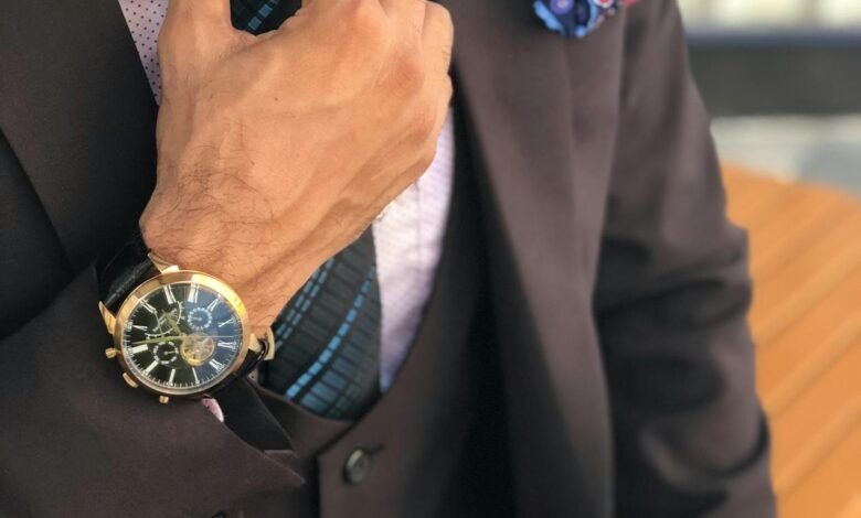 man in formal suit jacket holding his necktie