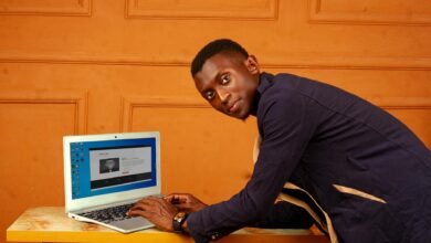 african man working on laptop in orange room