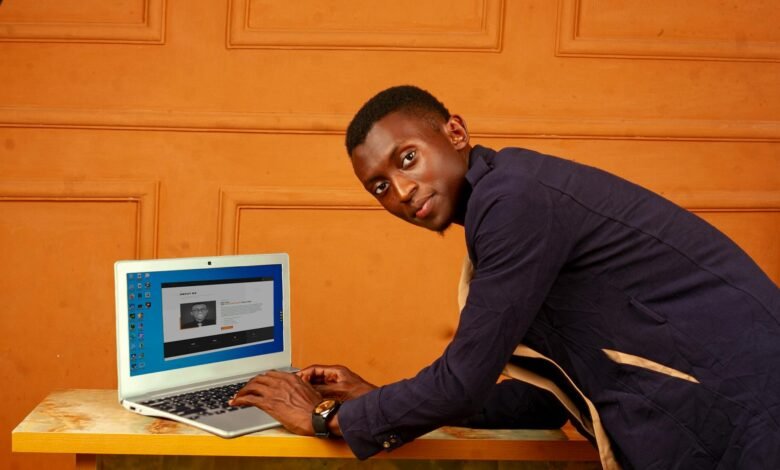 african man working on laptop in orange room