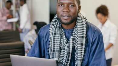 man with a scarf sitting with a laptop