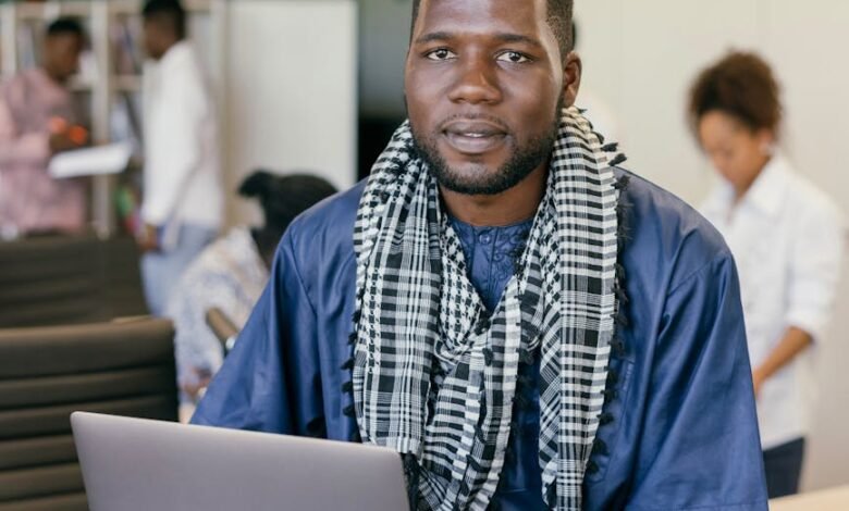 man with a scarf sitting with a laptop