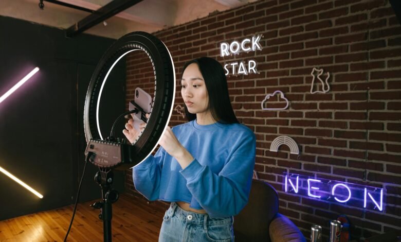 a woman using her phone while attached on a ring light