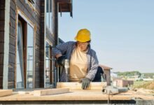 a woman in plaid long sleeve shirt holding a power tool