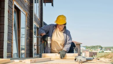 a woman in plaid long sleeve shirt holding a power tool