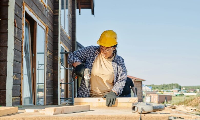 a woman in plaid long sleeve shirt holding a power tool