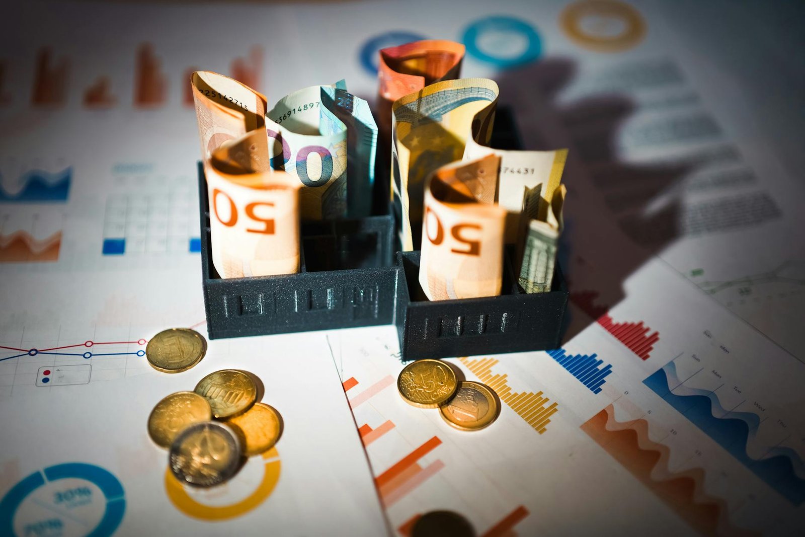 euro banknotes and coins on financial charts