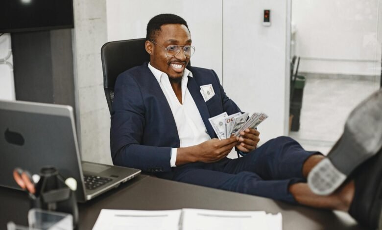 happy elegant man with money in office