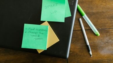green sticky note beside white and green pen