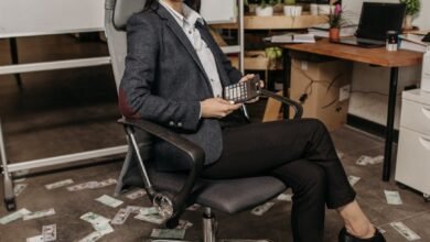 woman sitting on a gray swivel chair holding a calculator