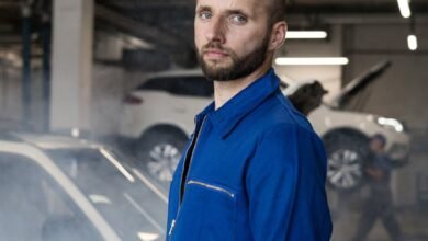 man in blue coverall standing near a car