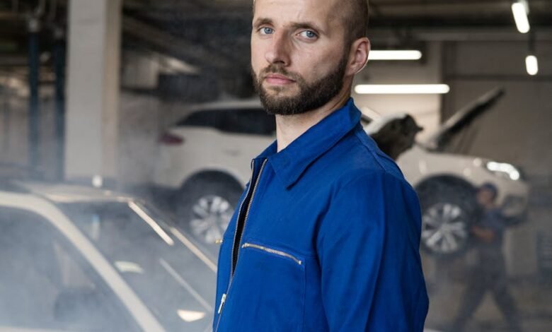man in blue coverall standing near a car